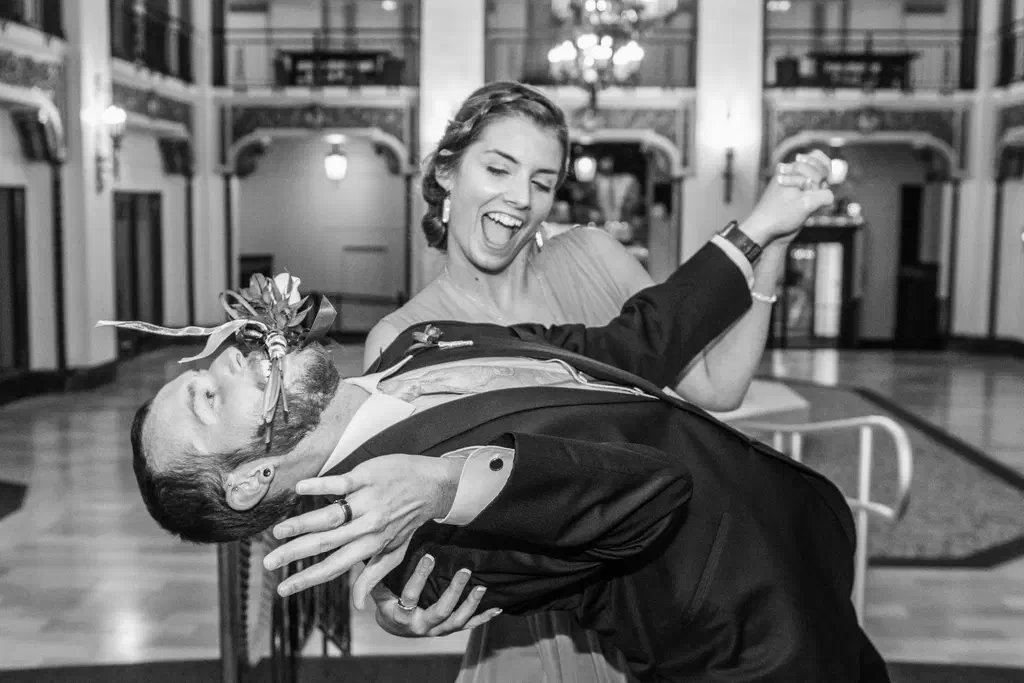A black and white photo of my friend's sister and myself, Gregory Dosh. We're both in formal attire and she's giving me a dip while I bend over backwards.
